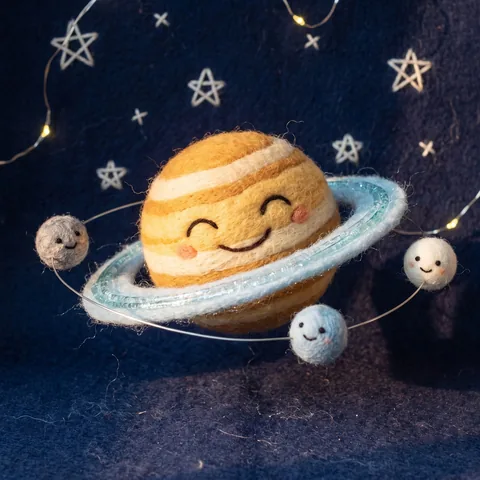 A happy felted wool Saturn spins its rings like a hula hoop while tiny felt moons cheer, stop-motion craft scene.